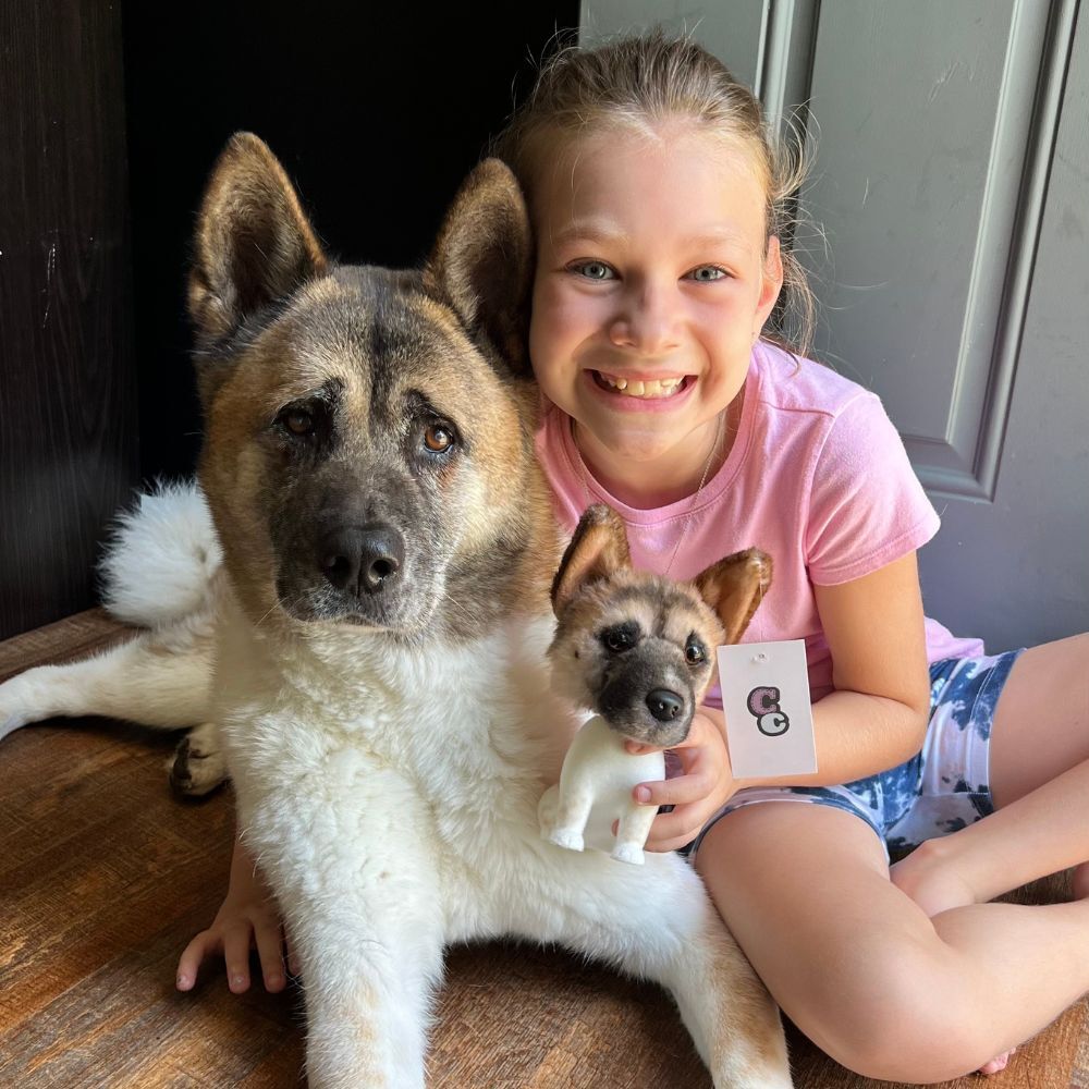 A cute kid with her dog while holding her CC bubblehead