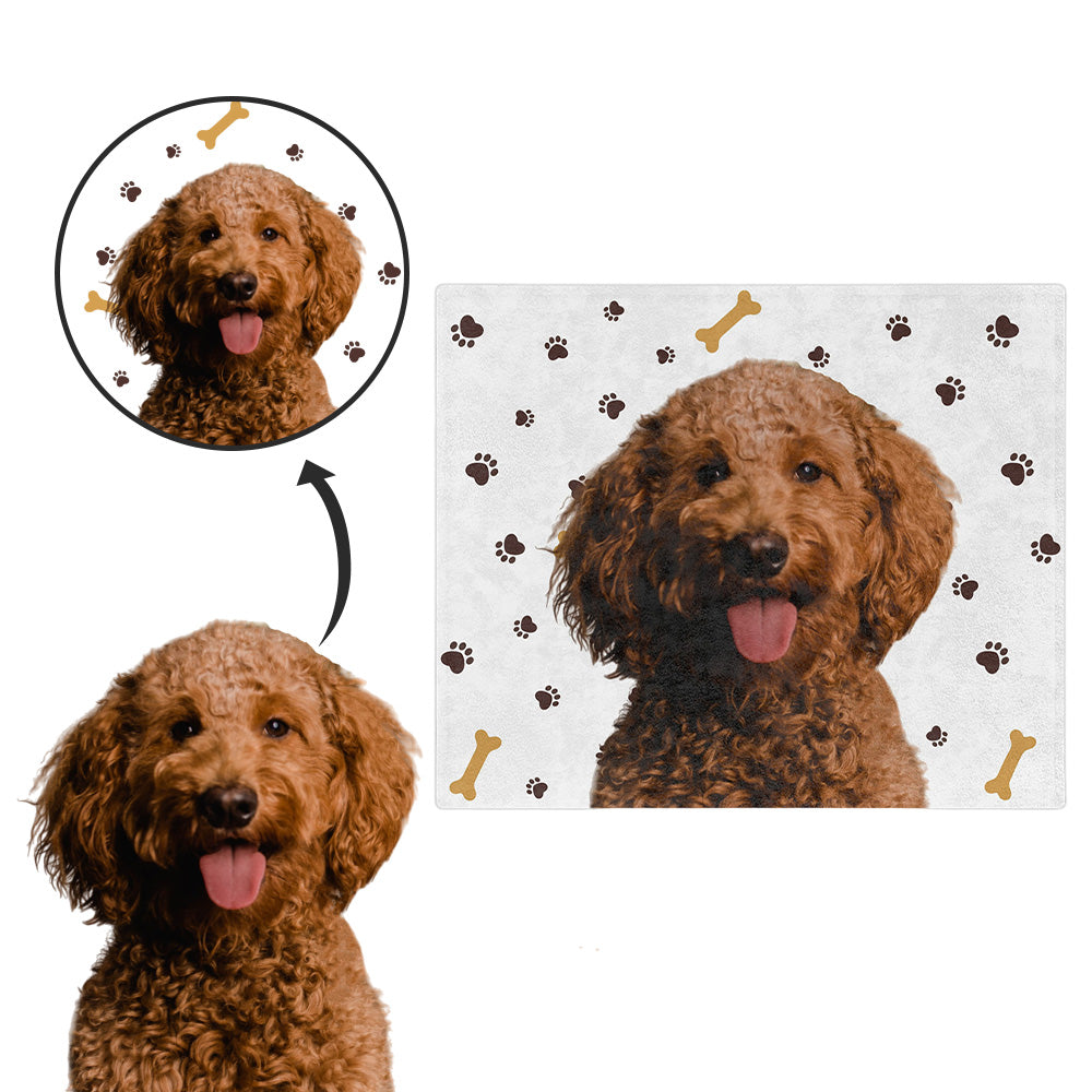 Dog with a custom face blanket featuring paw prints and bones on white.