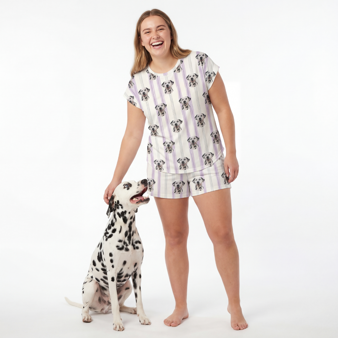 Woman wearing a patterned pajama set standing next to a Dalmatian dog on a white background[LilacStripes]