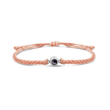 Pink braided bracelets with a black bead charm in silver color