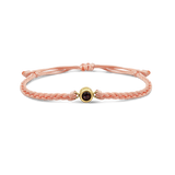 Pink braided bracelets with a black bead charm in gold color