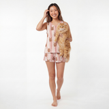 Woman in tank top pajamas holding a cat on a white background[TerracottaStripes]