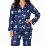 A woman modeling a navy blue long-sleeve pajama set with a Christmas-themed print featuring dog portraits, Santa hats, wreaths, and the text 'Christmas Vacation.' The photo is cropped from the lower face to the upper thighs against a plain light gray studio background.