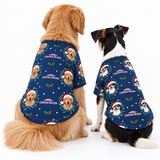 Two dogs sitting side by side wearing matching navy blue Christmas-themed dog shirts with a printed pattern of golden retriever faces, Santa hats, holly leaves, and white text reading 'HARVESTING CHRISTMAS WOODEN'.