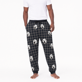 Person wearing black plaid pajama pants with dog pattern on a white background