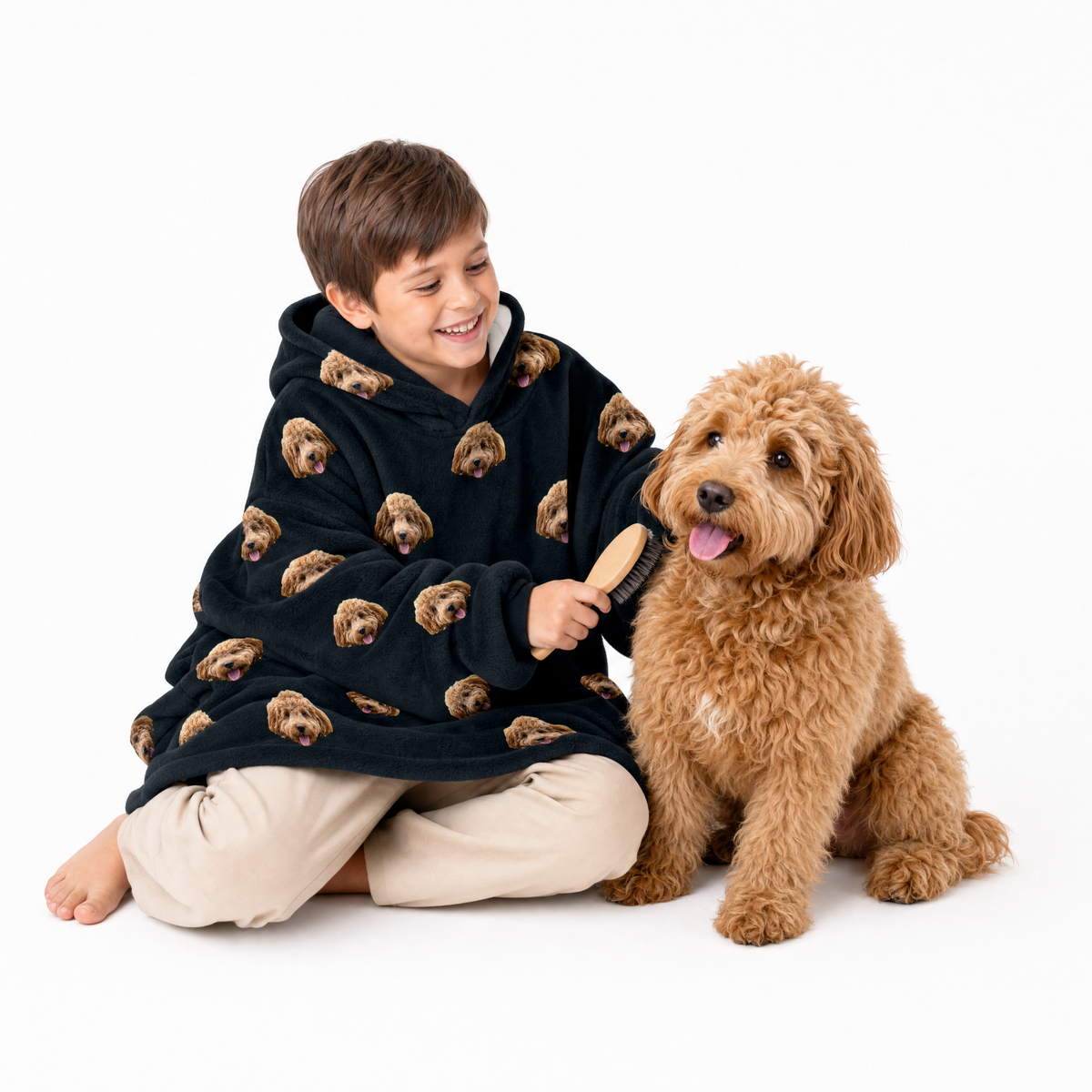 Black kids fleece blanket hoodie theme – child in dog-print hoodie brushing fluffy light brown dog.