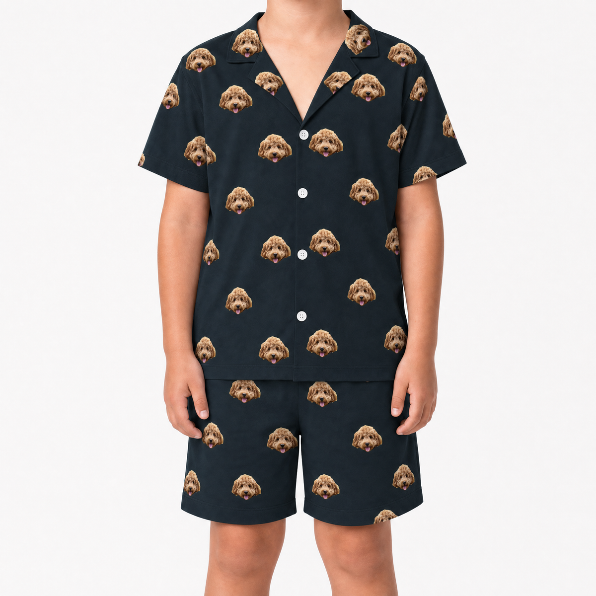 Child wearing a black pajama set with dog face pattern on a white background