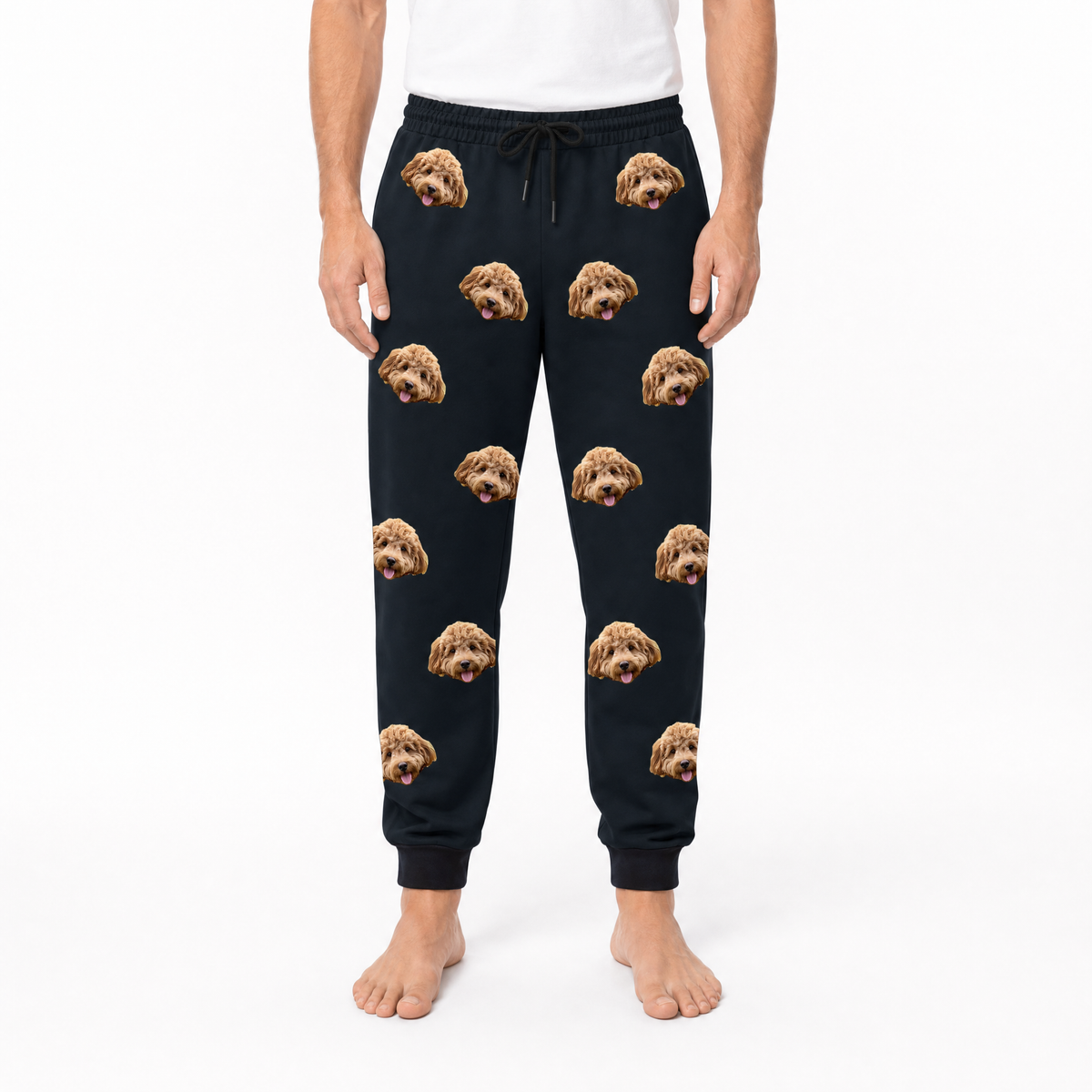 Person wearing black sweatpants with dog face pattern on a white background