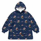 A navy blue hooded sweatshirt with an all-over Christmas print featuring Santa Claus, penguins, wreaths, snowflakes, and the text 'Christmas with the Kriss Angel'. The hoodie has a white fleece lining inside the hood and a front kangaroo pocket, shown against a plain white background.