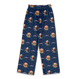 A pair of navy blue holiday pajama pants featuring a repeating pattern of golden retriever dog illustrations wearing red Santa hats, surrounded by green wreaths and white snowflakes.