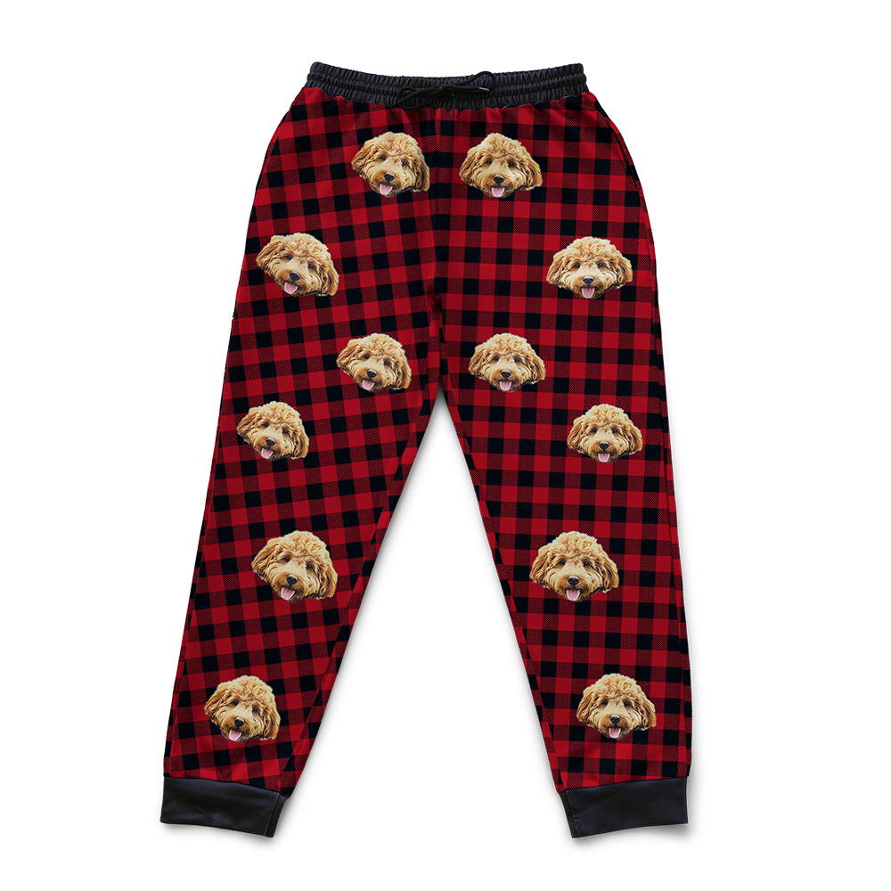 Red and black checkered sweatpants with a dog's face pattern on a white background
