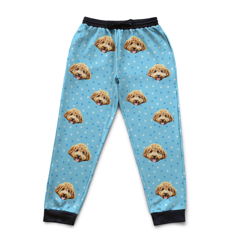 Light blue pajama pants with dog face pattern on a white background