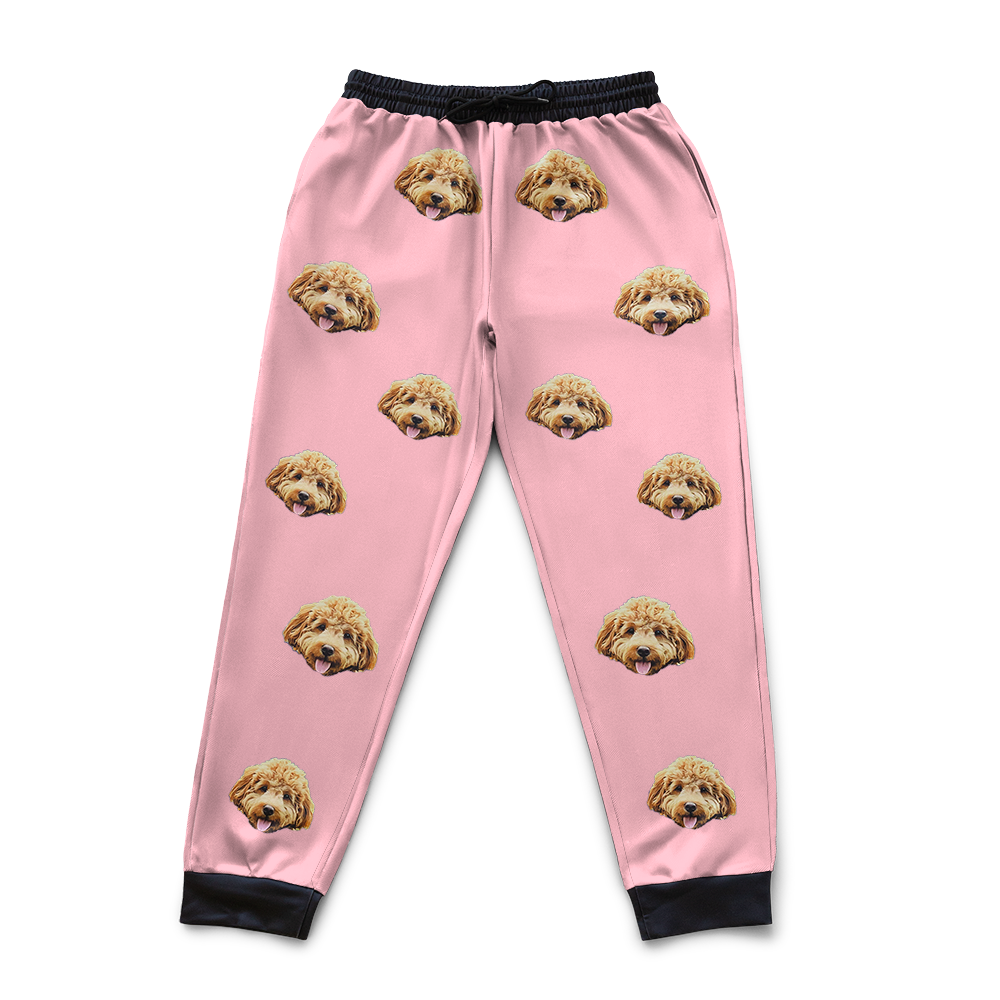 Pink pajama pants with dog face pattern on a white background