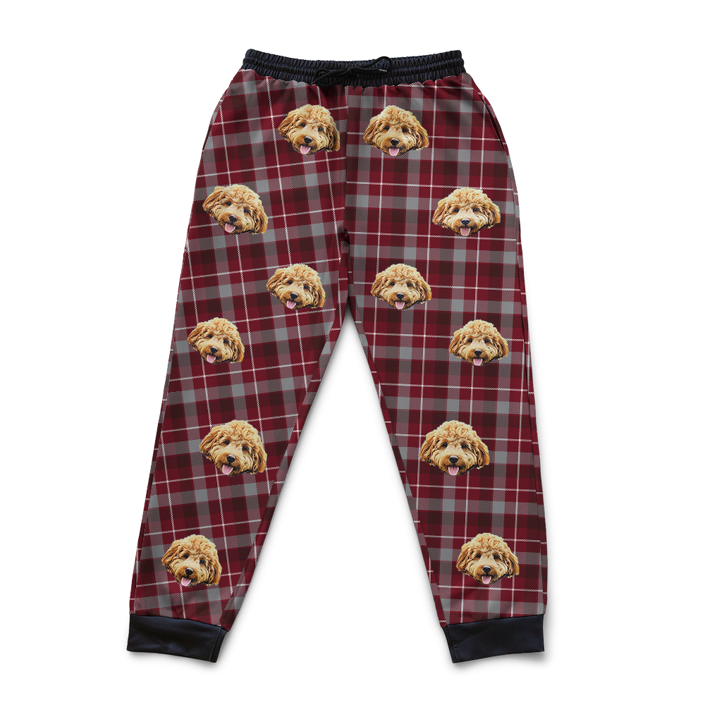 Red and gray plaid pajama pants with dog face pattern on a white background