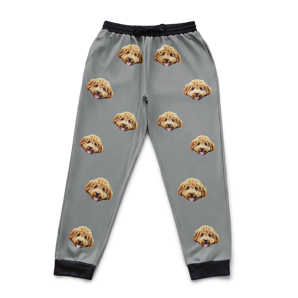 Gray pajama pants with dog face pattern on a white background