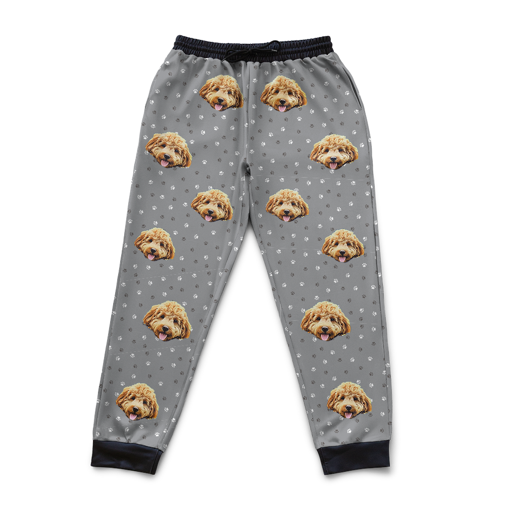 Gray pajama pants with dog face pattern on a white background