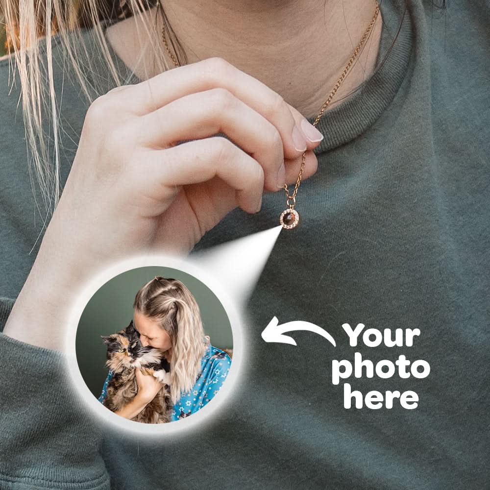 Person wearing a gold photo-projection necklace with an inset image of a woman and cat.