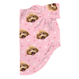 Light pink dog pajama with repeating pet faces on them