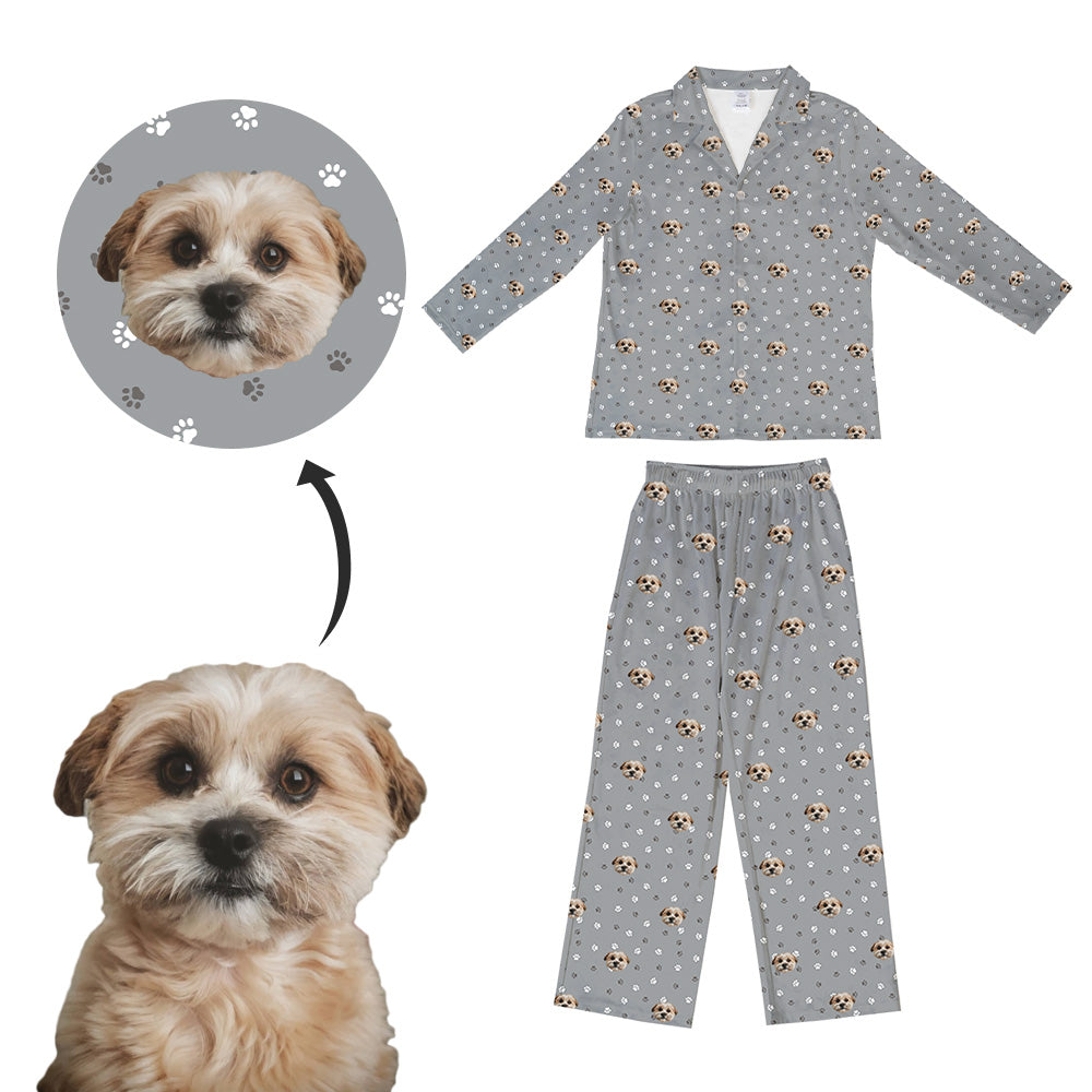 A set of kids' pajamas with a custom print of a dog's face on the top. The pajamas are shown with a long-sleeve shirt and pants, featuring a pattern with small images of dogs and paws.