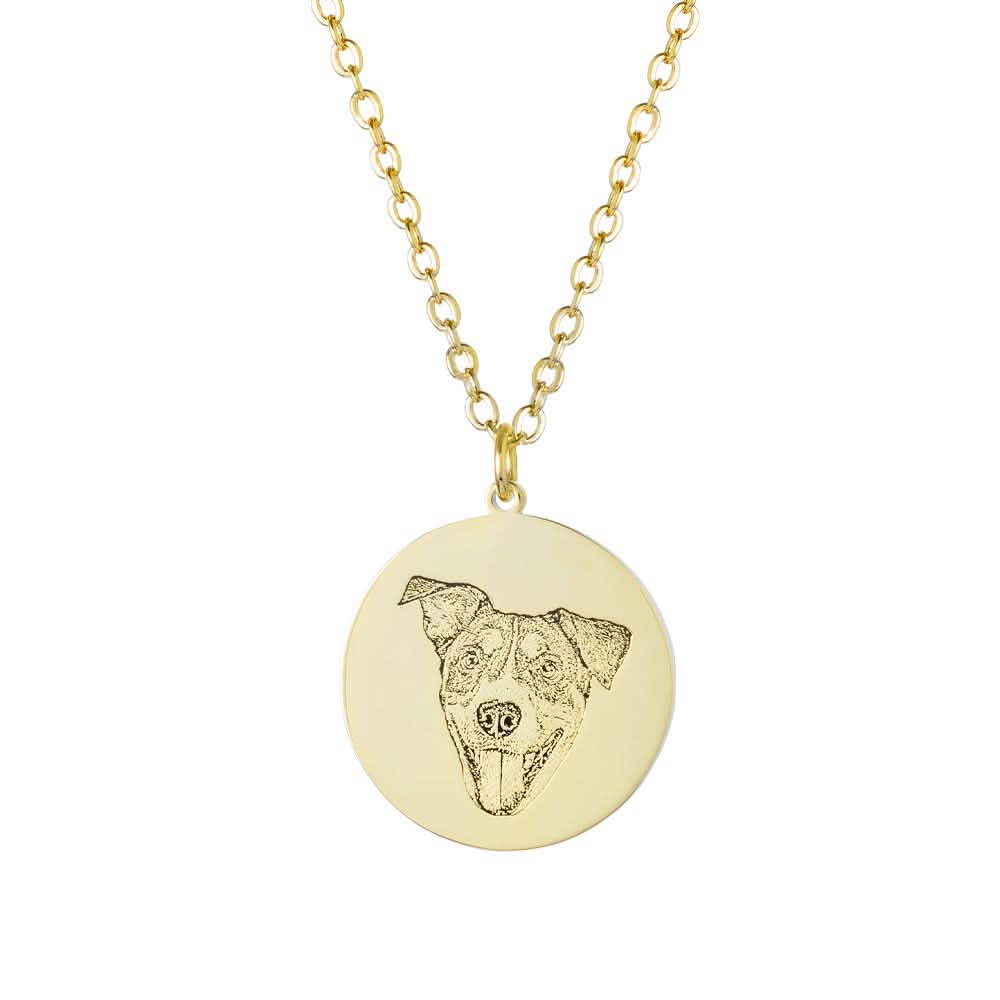 Close-up of a gold circular pendant with a detailed engraved dog portrait.