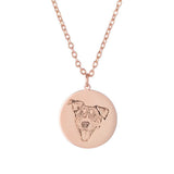 Rose gold dog-portrait necklace with a blue gemstone detail on the pendant.