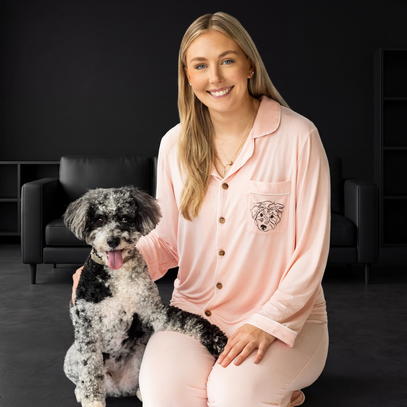 A woman in a pink bamboo pajama set with short sleeves and pants, sitting next to a dog. 