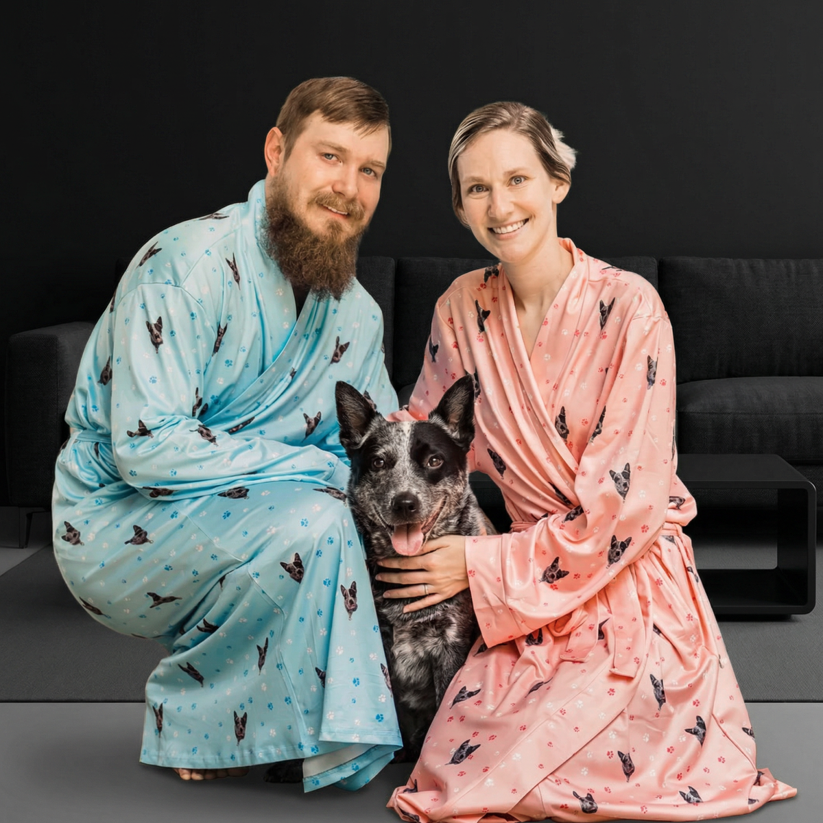 Two people in patterned robes with a dog on a dark background
