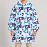 A person wearing an oversized hooded sweatshirt and matching shorts set with a repeating cartoon dog print on a light blue and white background. The print features black and white dogs in red scarves and blue panels.