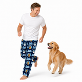 A man wearing navy blue patterned pajama pants and a white t-shirt is running barefoot next to a golden retriever dog on a solid white background.