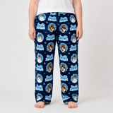 A person wearing navy blue pajama pants with a repeating 'Frosty Snowman' dog print, shown from the waist down against a light gray studio background.