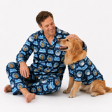 A man and a golden retriever dog sitting together on a white studio background, both wearing matching navy blue pajamas with a repeating cartoon dog print and the text 'Best Friends'.