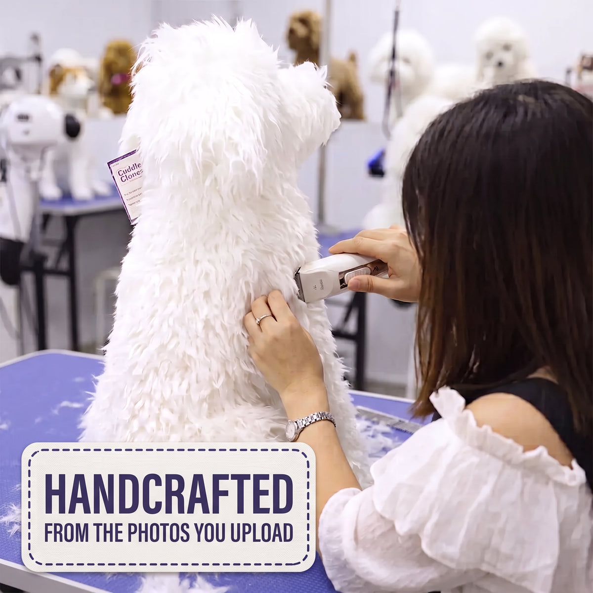 A woman grooming a fluffy white dog with an electric clipper in a grooming salon. A purple tag is attached to the dog, and a 'HANDCRAFTED FROM THE PHOTOS YOU UPLOAD' graphic overlay is in the bottom left corner.
