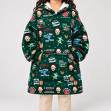 A person wearing a dark green Christmas-themed hoodie with an all-over print of dog portraits, Santa hats, trees, and text including 'A Griswold Christmas' and 'Don't Twig Too Much.' The photo is cropped from the mouth down against a plain light gray studio background.