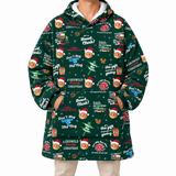 A person wearing a dark green Christmas-themed hooded sweatshirt with an all-over print of Santa-clad dog faces, holiday text, ornaments, and festive illustrations, paired with light beige pants against a plain white background.