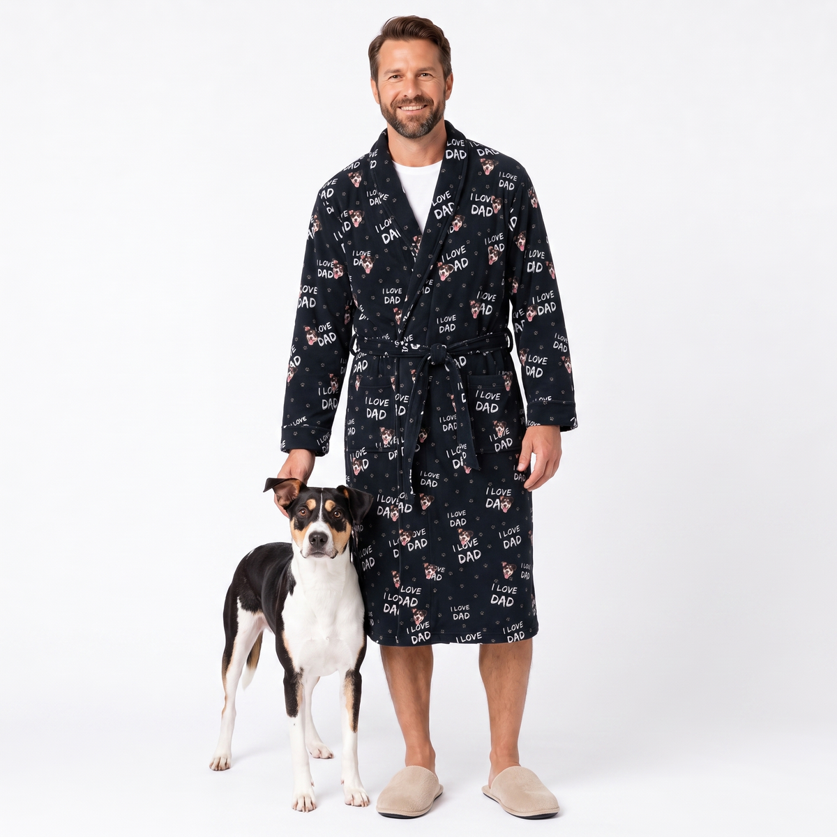 A man wearing a black 'I Love Dad' print robe stands next to a black and white dog on a white studio background.