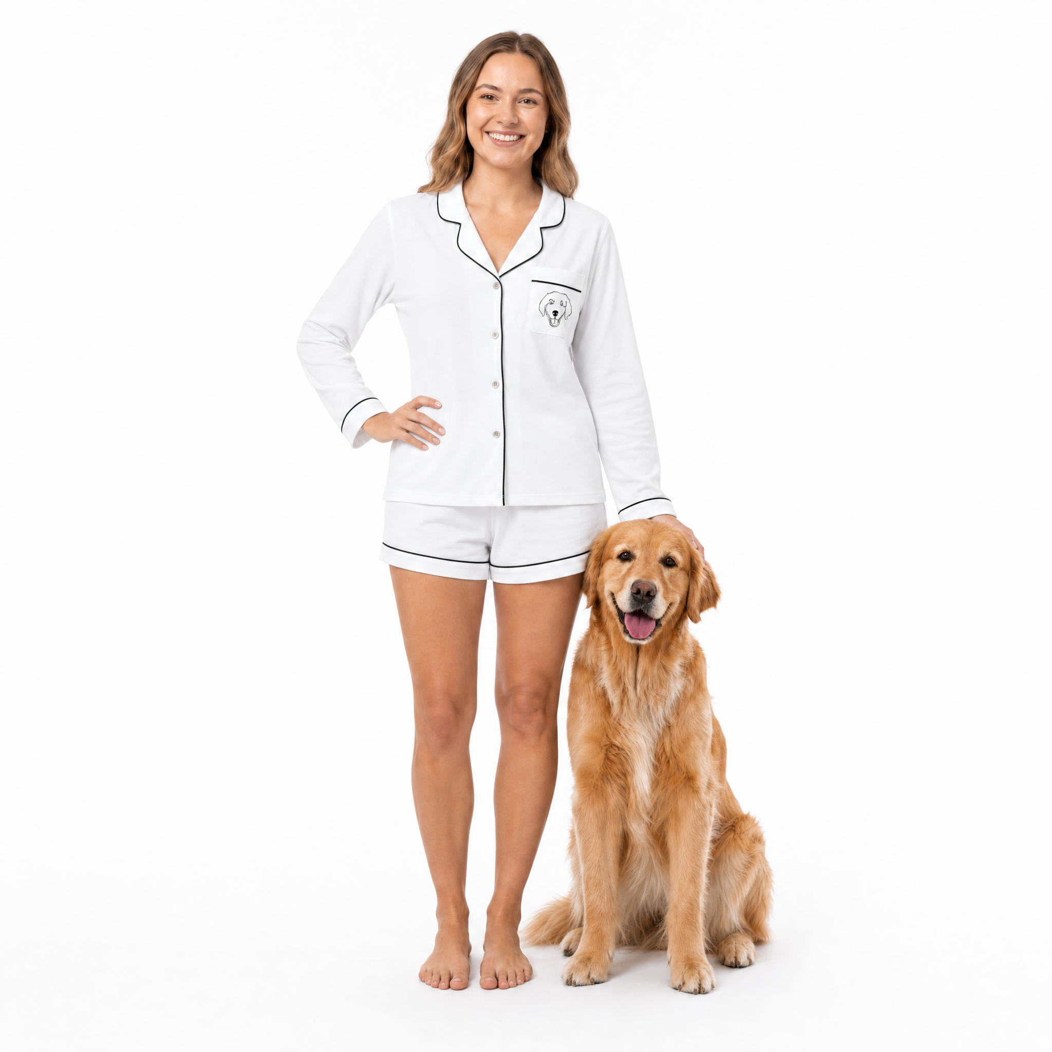 Woman wearing ivory pajamas standing next to a golden retriever on a white background