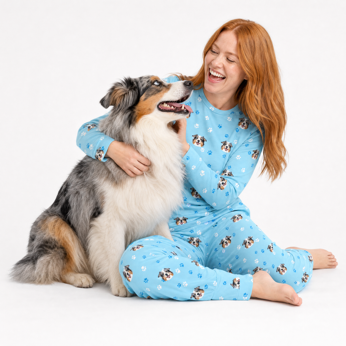 Woman in matching jogger pajamas with a dog on a white background