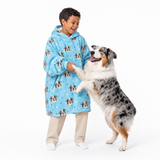Light blue paws kids fleece blanket hoodie theme – child in dog-print hoodie playing with Australian Shepherd.