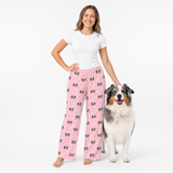 Woman wearing pink pajama pants with a dog on a white background