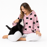 Light pink paws theme – person in cat-print hoodie petting black-and-white cat.