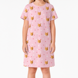 Pink nightgown with cat pattern worn by a person on a white background
