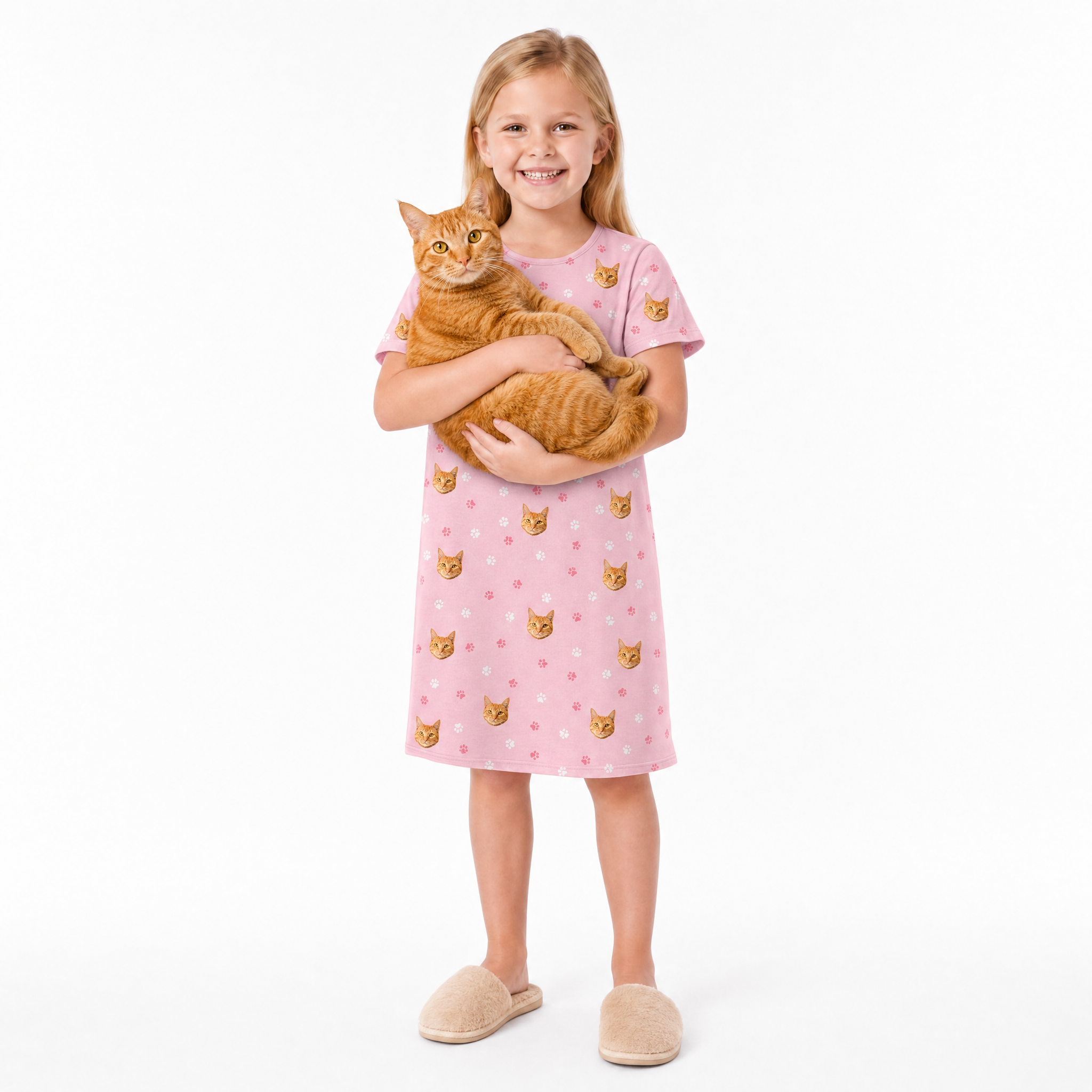 Girl in a pink nightgown with cat pattern holding an orange cat on a white background