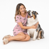 Light pink paws kids fleece blanket hoodie theme – person in dog-print dress cuddling fluffy multicolored dog.
