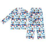 A two-piece children's pajama set featuring a long-sleeve button-up top and matching pants, both covered in a repeating cartoon print of Elsa and Anna from Frozen on a white background.