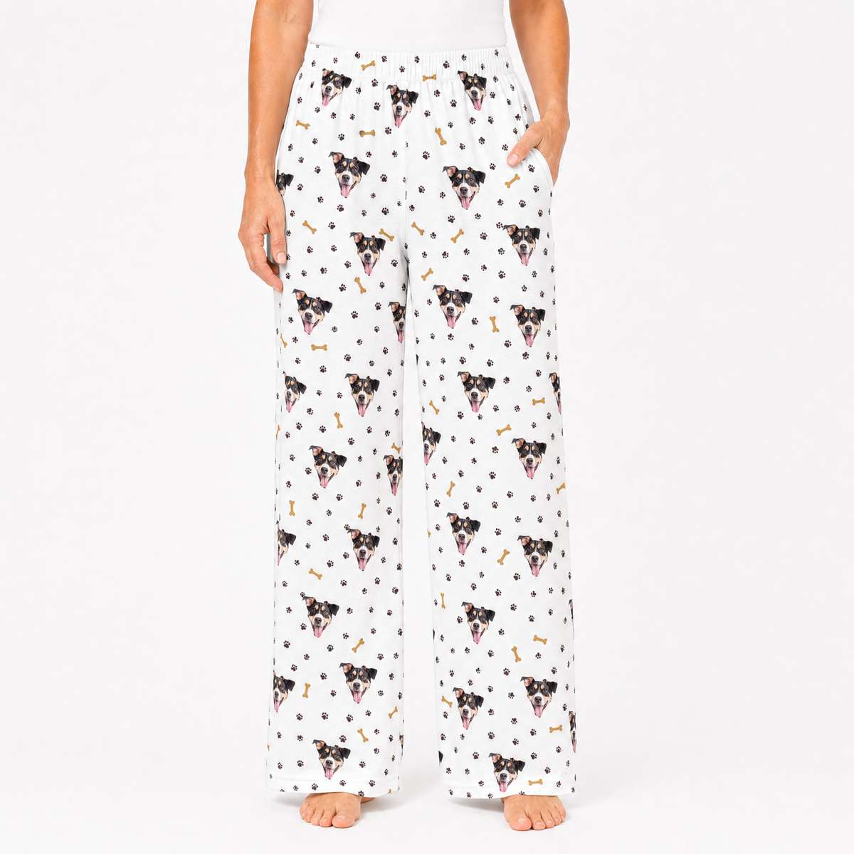 Person wearing white pajama pants with dog pattern on a white background