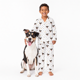 Child wearing a white patterned pajama set with a dog on a white background