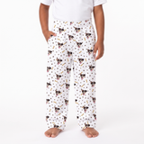 paw and bones pajama pants with an all-over print of Boston Terrier dog faces, black polka dots, and small gold bones, modeled on a child against a white background.