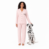 Woman in pink pajamas with a Dalmatian dog on a white background