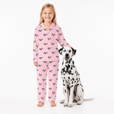 Girl in pink pajamas with dog on a white background