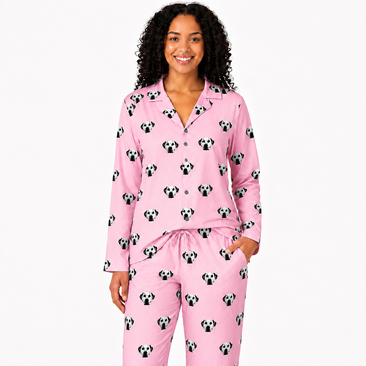 Woman wearing pink pajamas with dog pattern on a white background